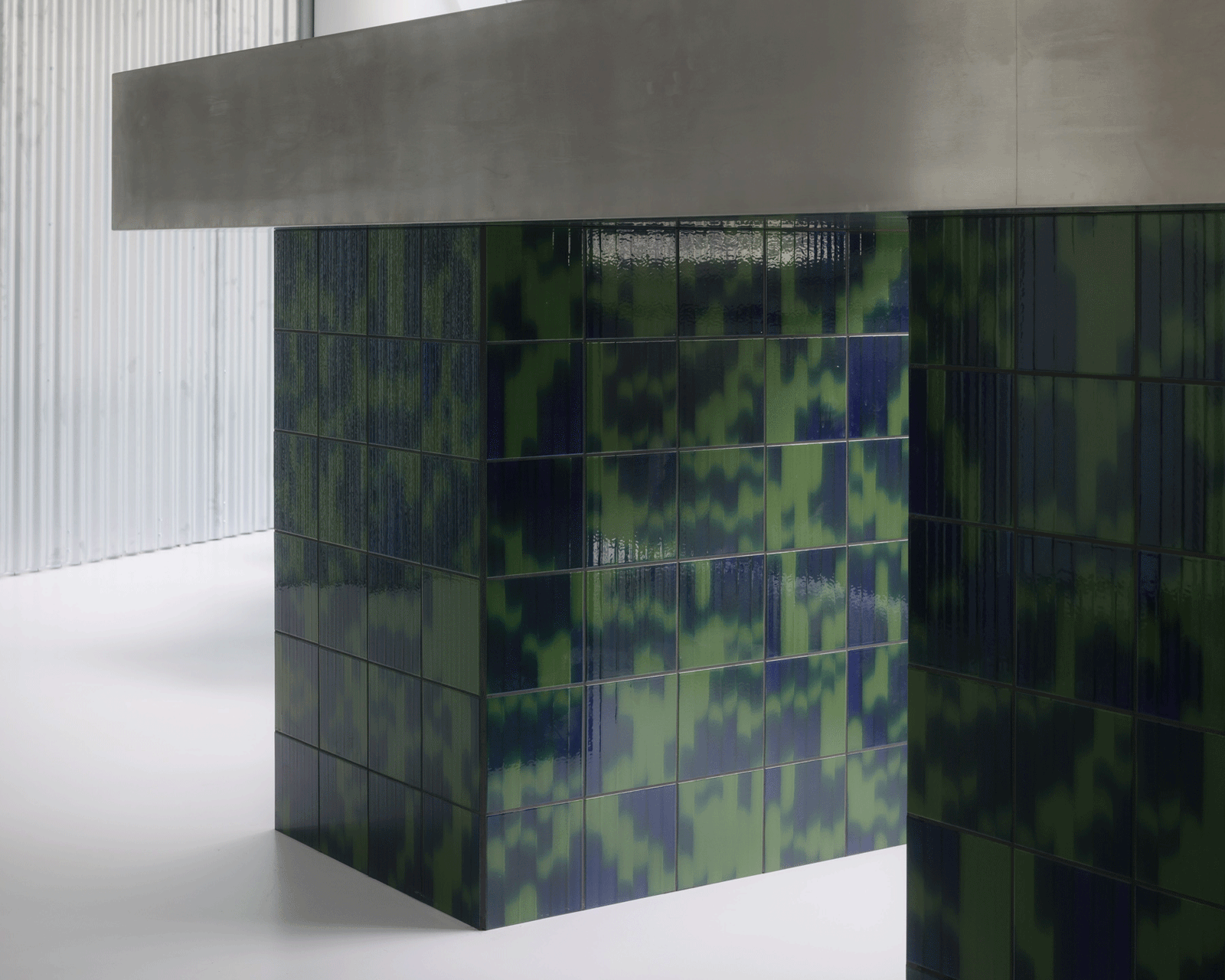 Reception counter clad in patterned green and blue tiles