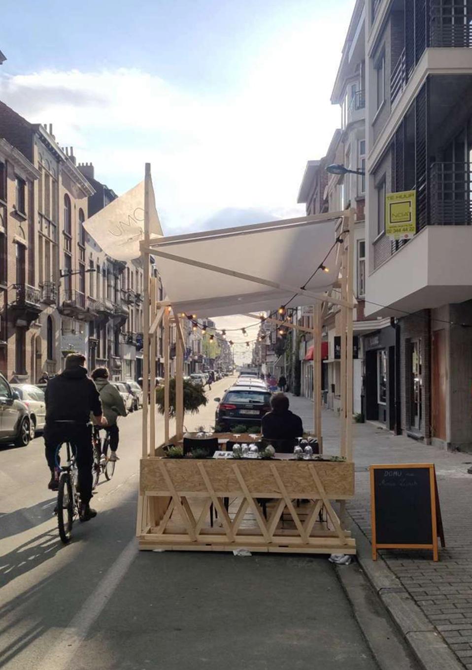 Timber parklet and fabric canopy occupying a city parking space