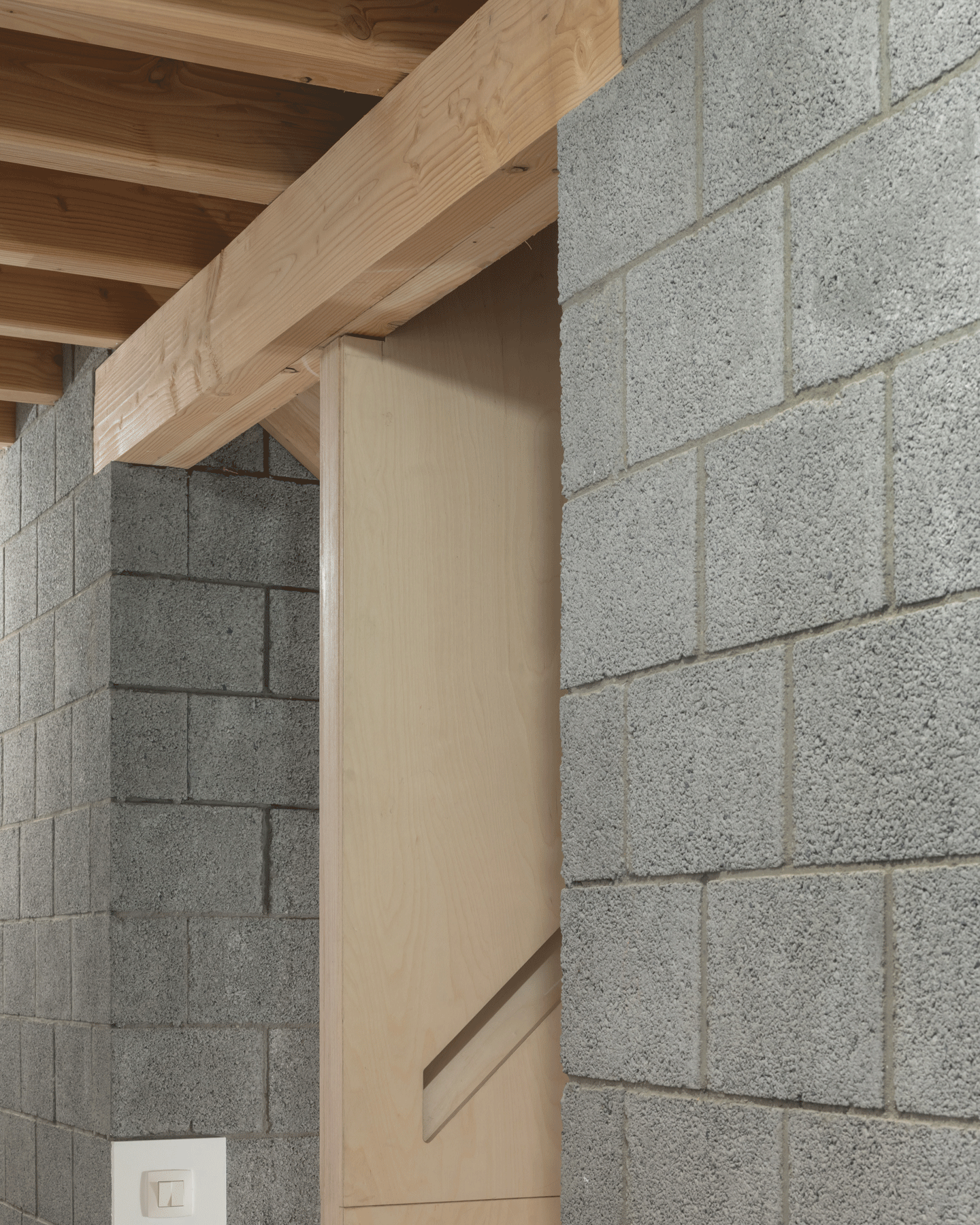 Junction of timber ceiling, concrete slab and block wall