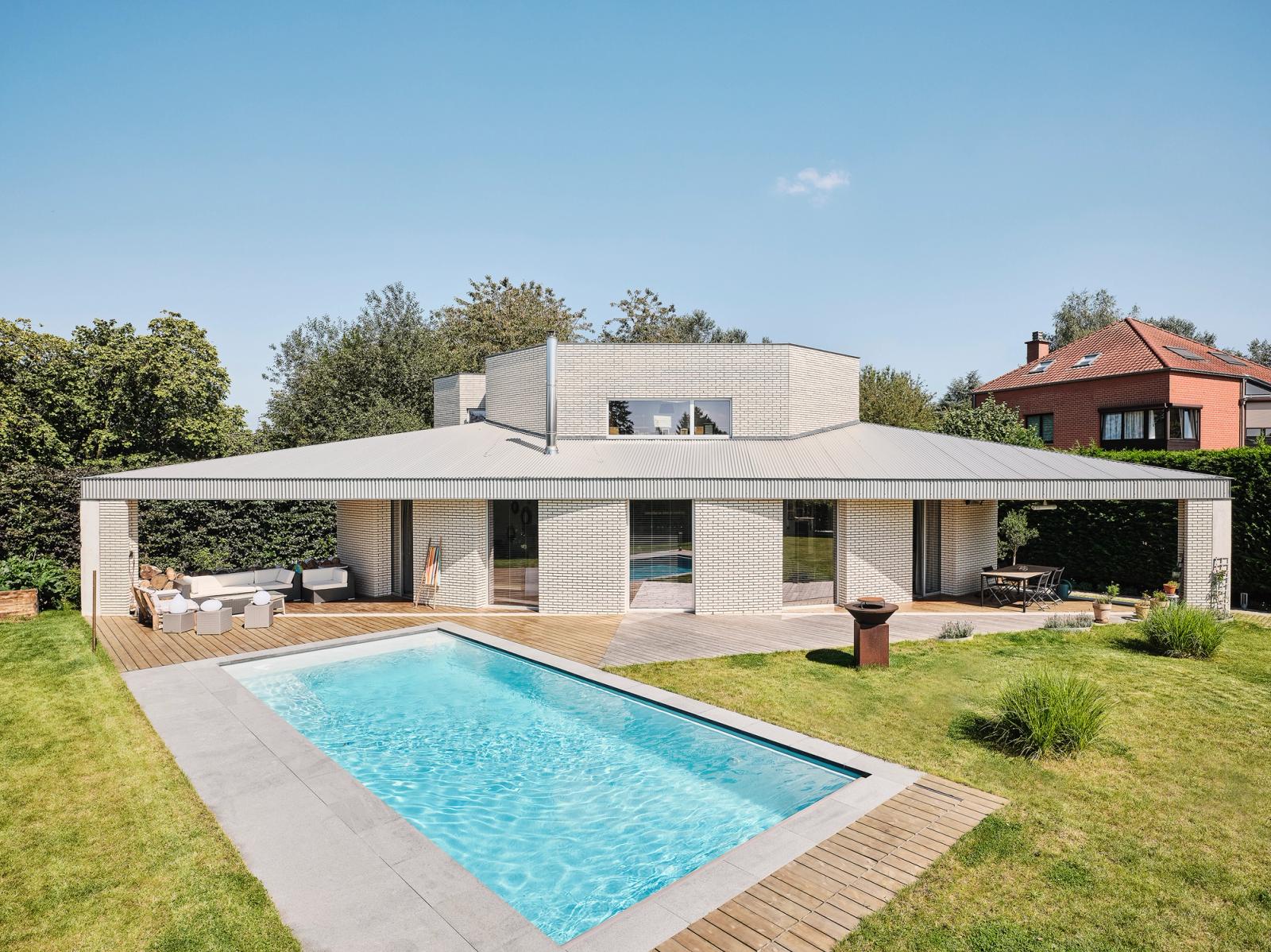 Low Triangle House facing a garden swimming pool