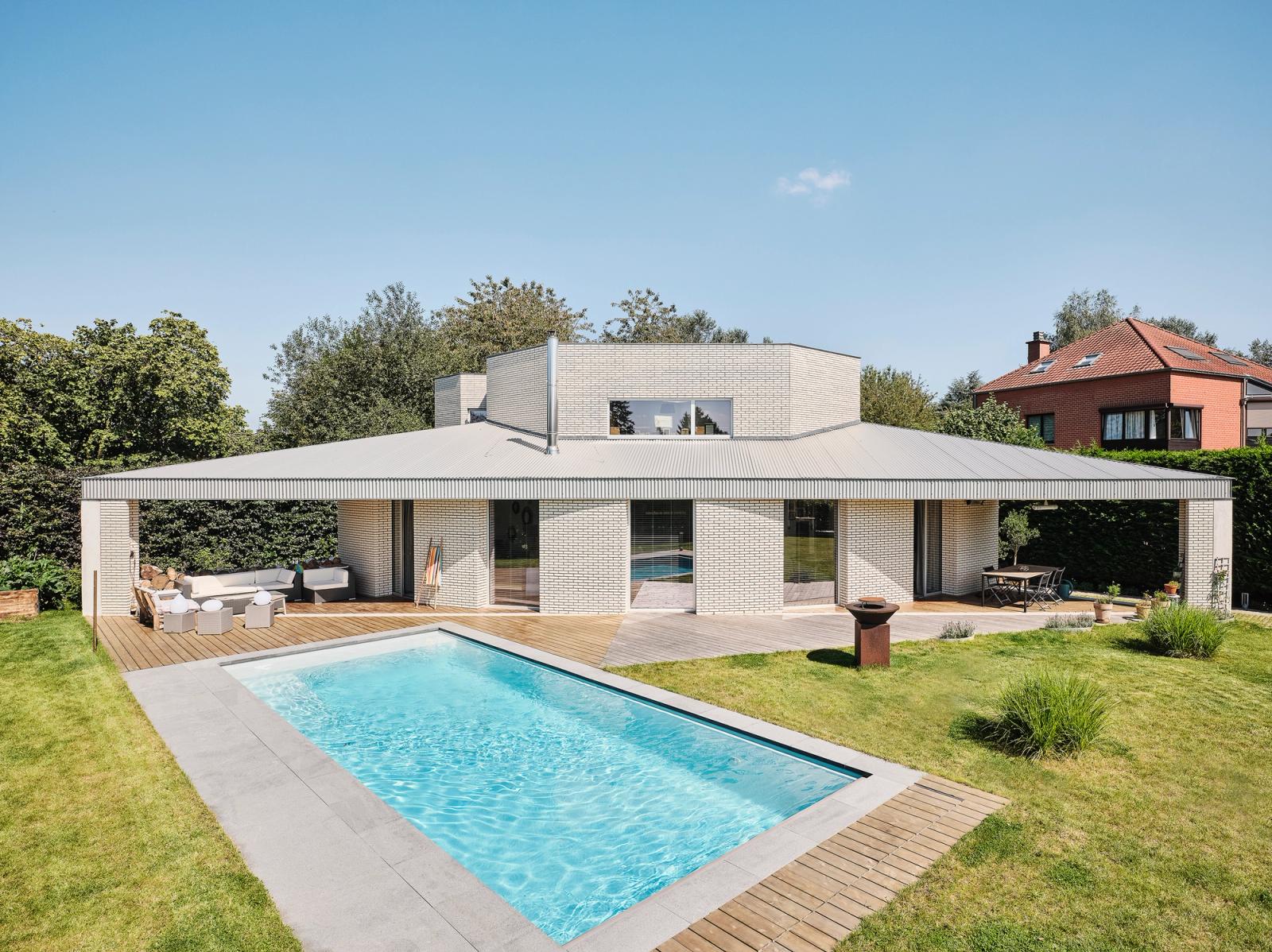 Low Triangle House facing a garden swimming pool