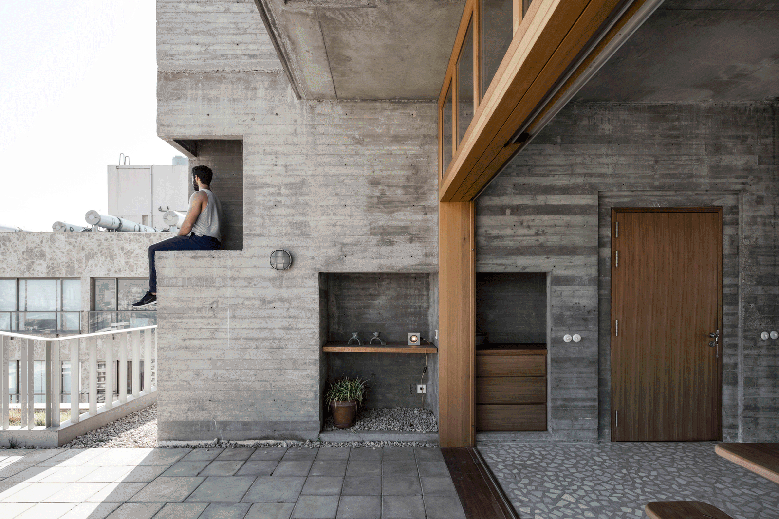 Concrete terrace wall beside a timber door and open city view