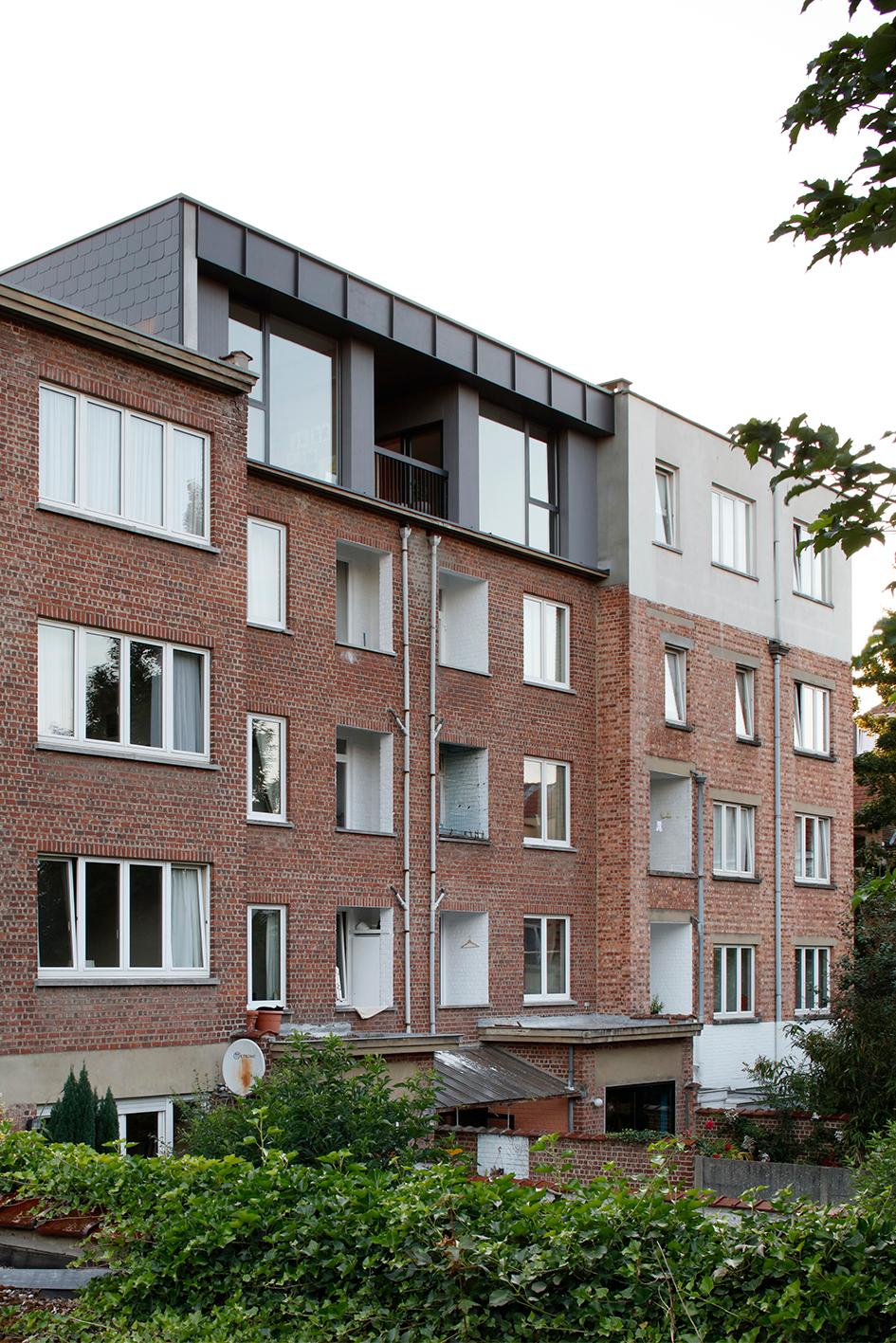 Rear view of the brick apartment block and dark rooftop extension