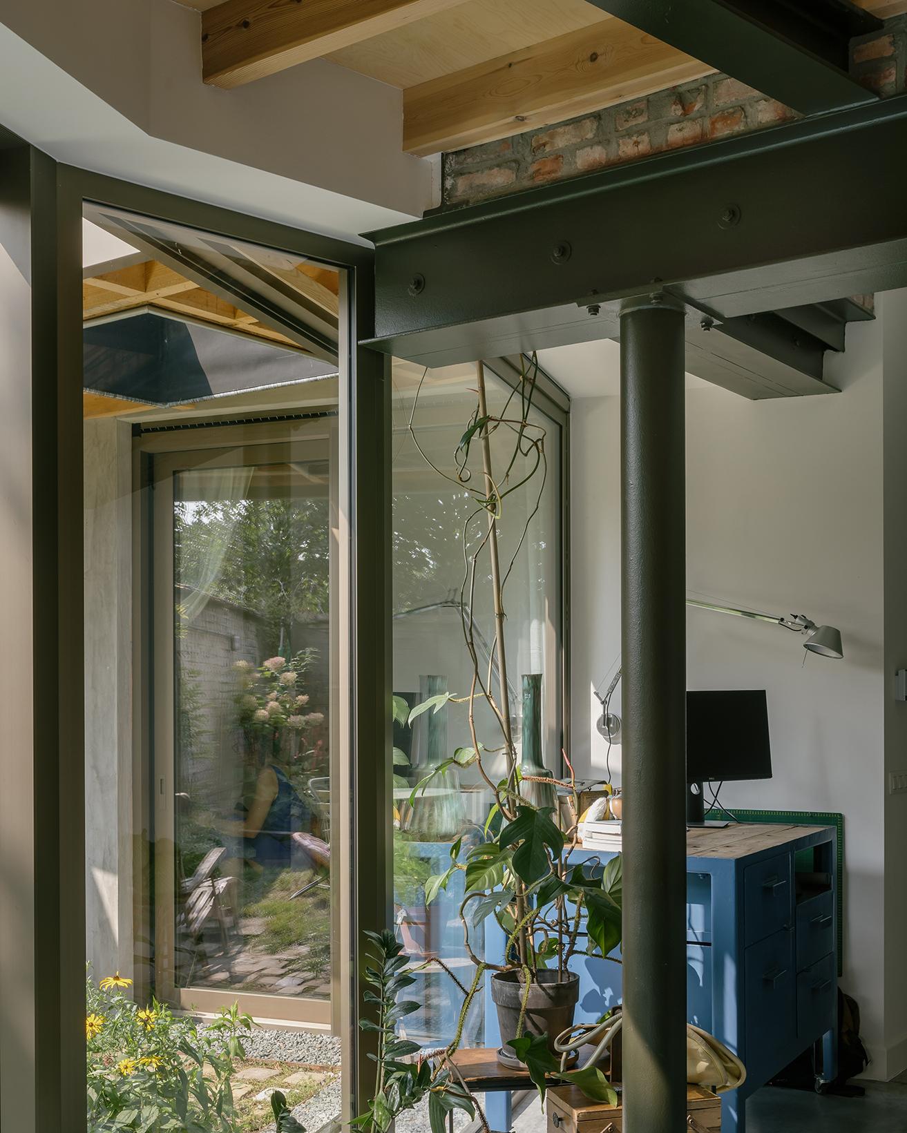 Interior corner where green steel, brick and glazing meet