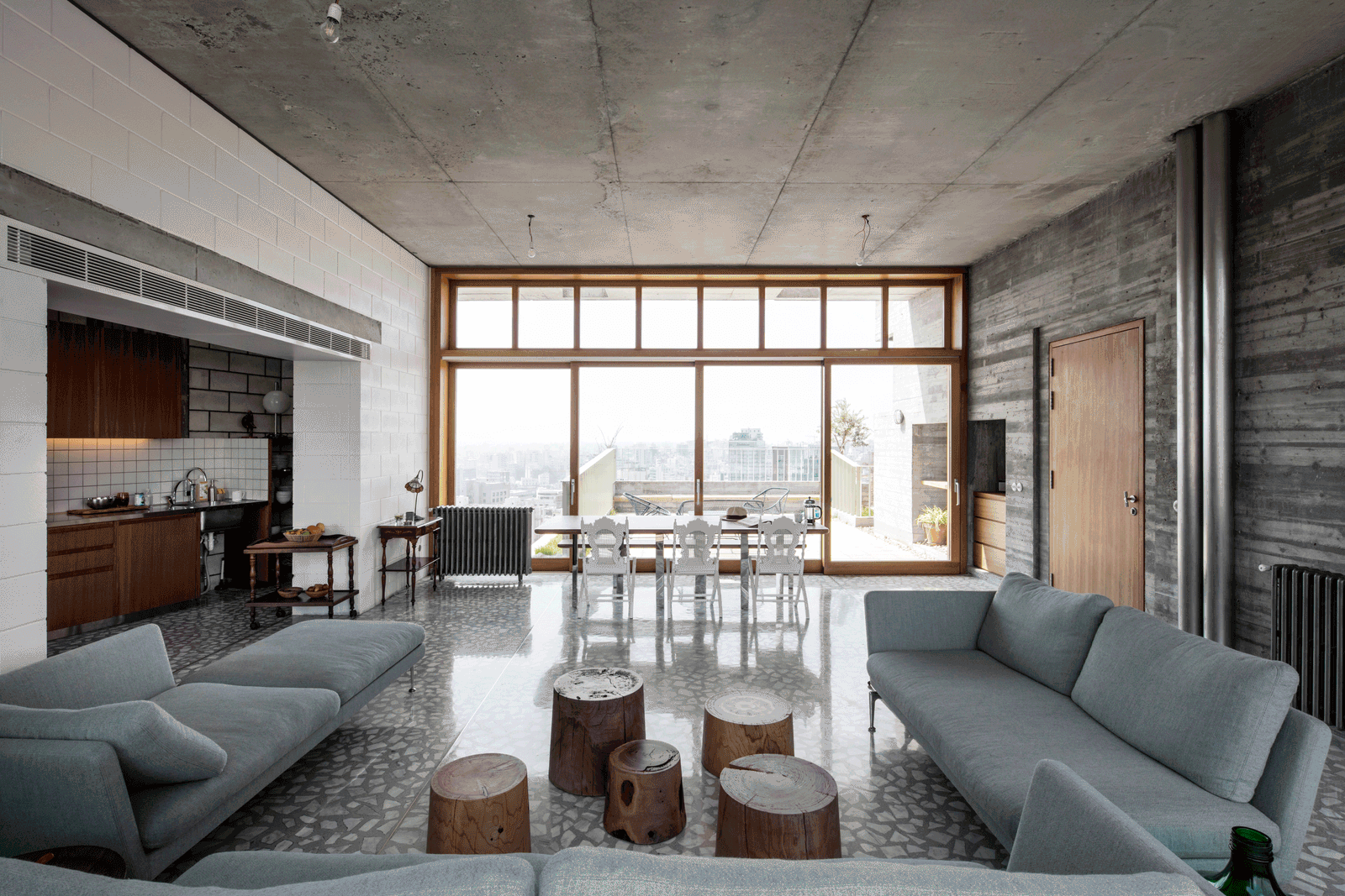 Living room with exposed concrete, timber windows and city view