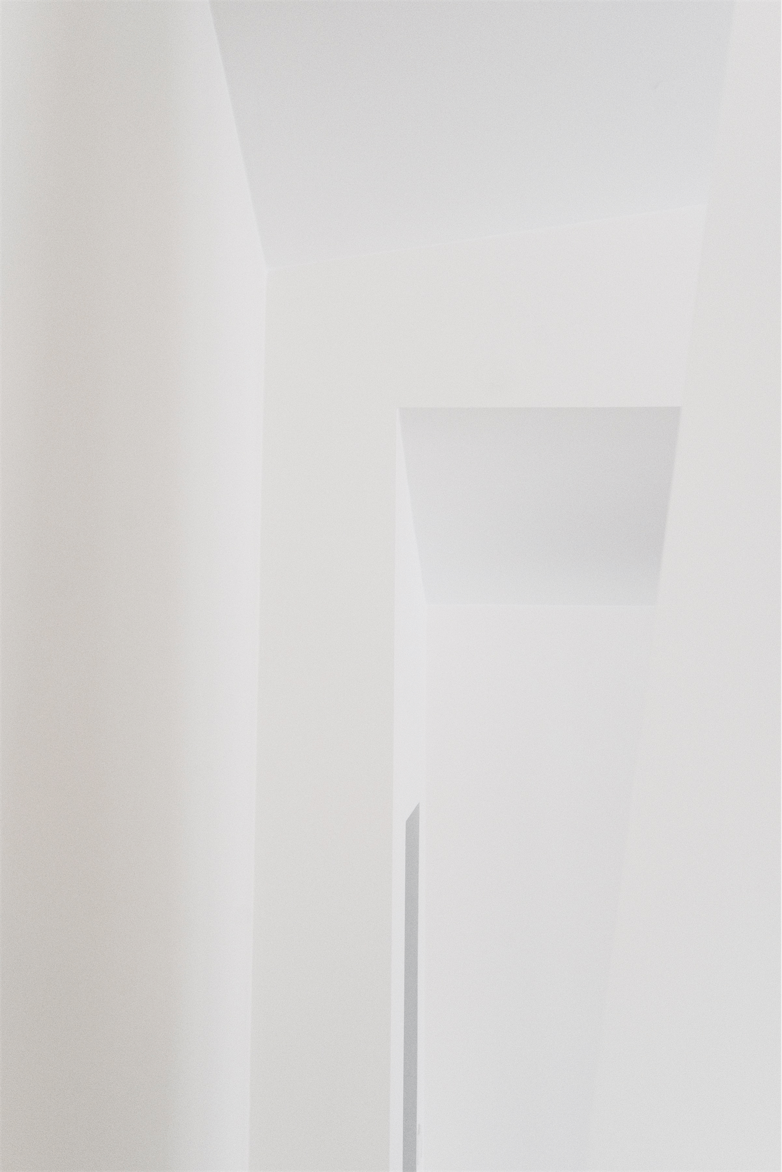 White interior stair concealed within a narrow wall recess