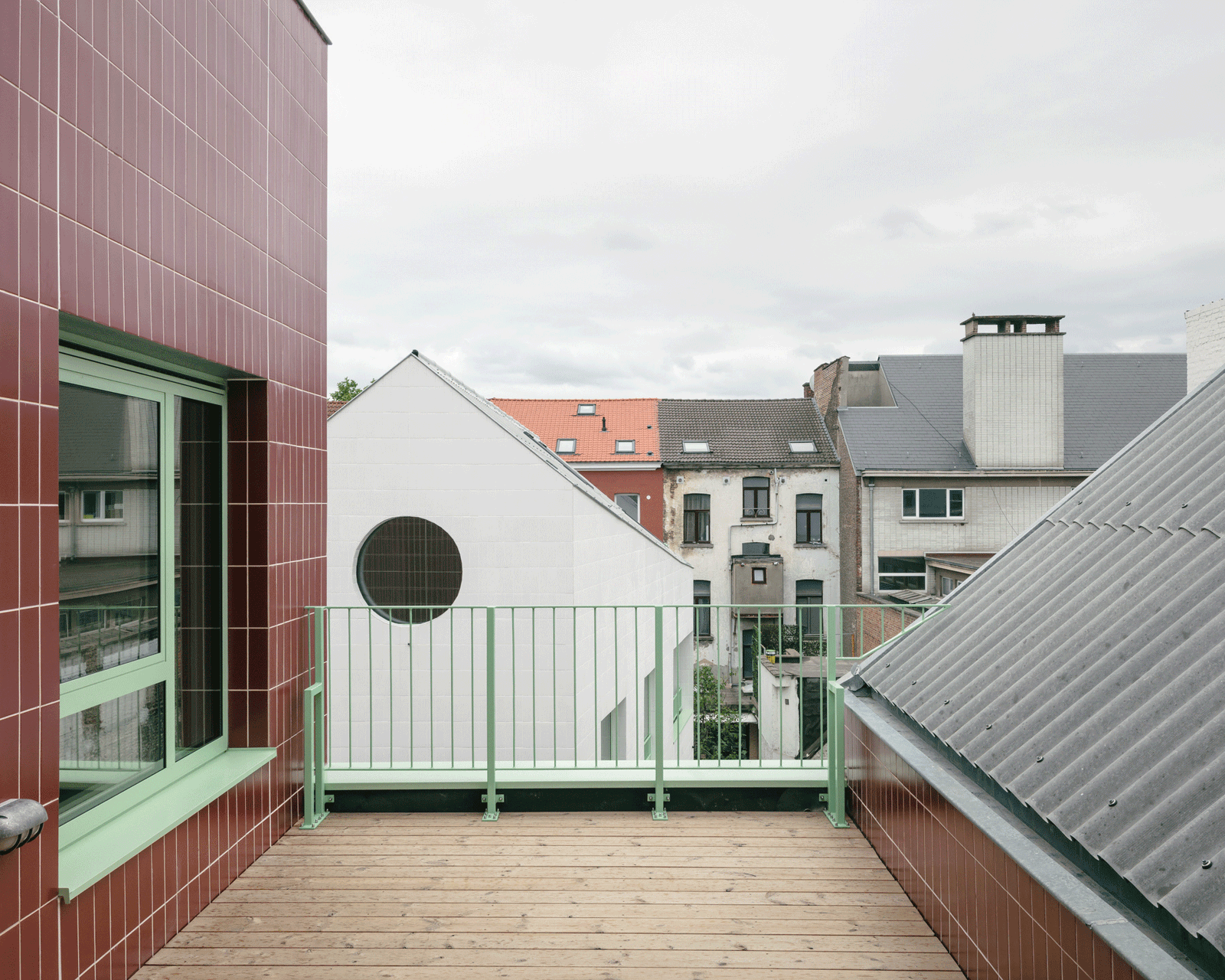 Roof terrace linking the red-tiled façade to a white gable