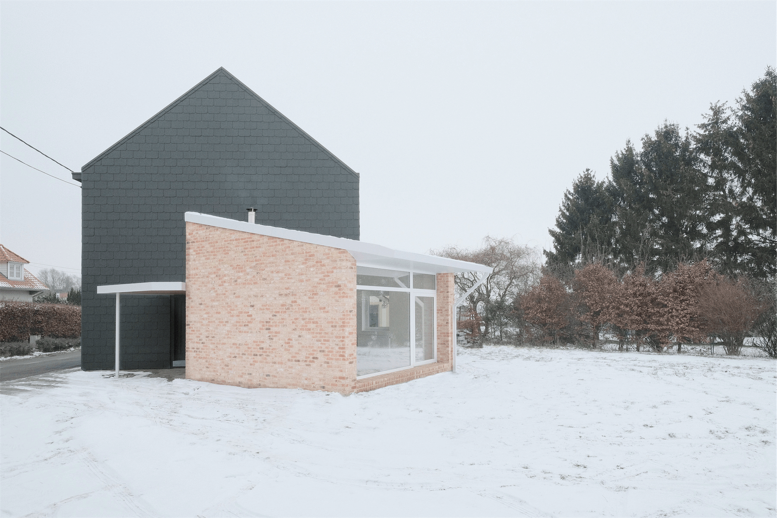 Full garden view of the dark house and low brick extension