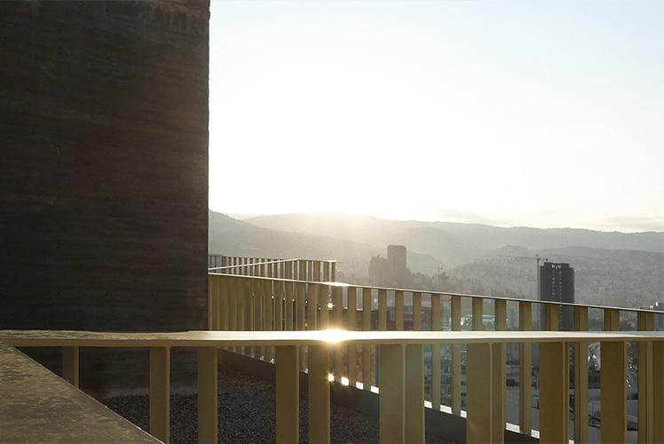 Sunset view across the terrace railing to distant hills