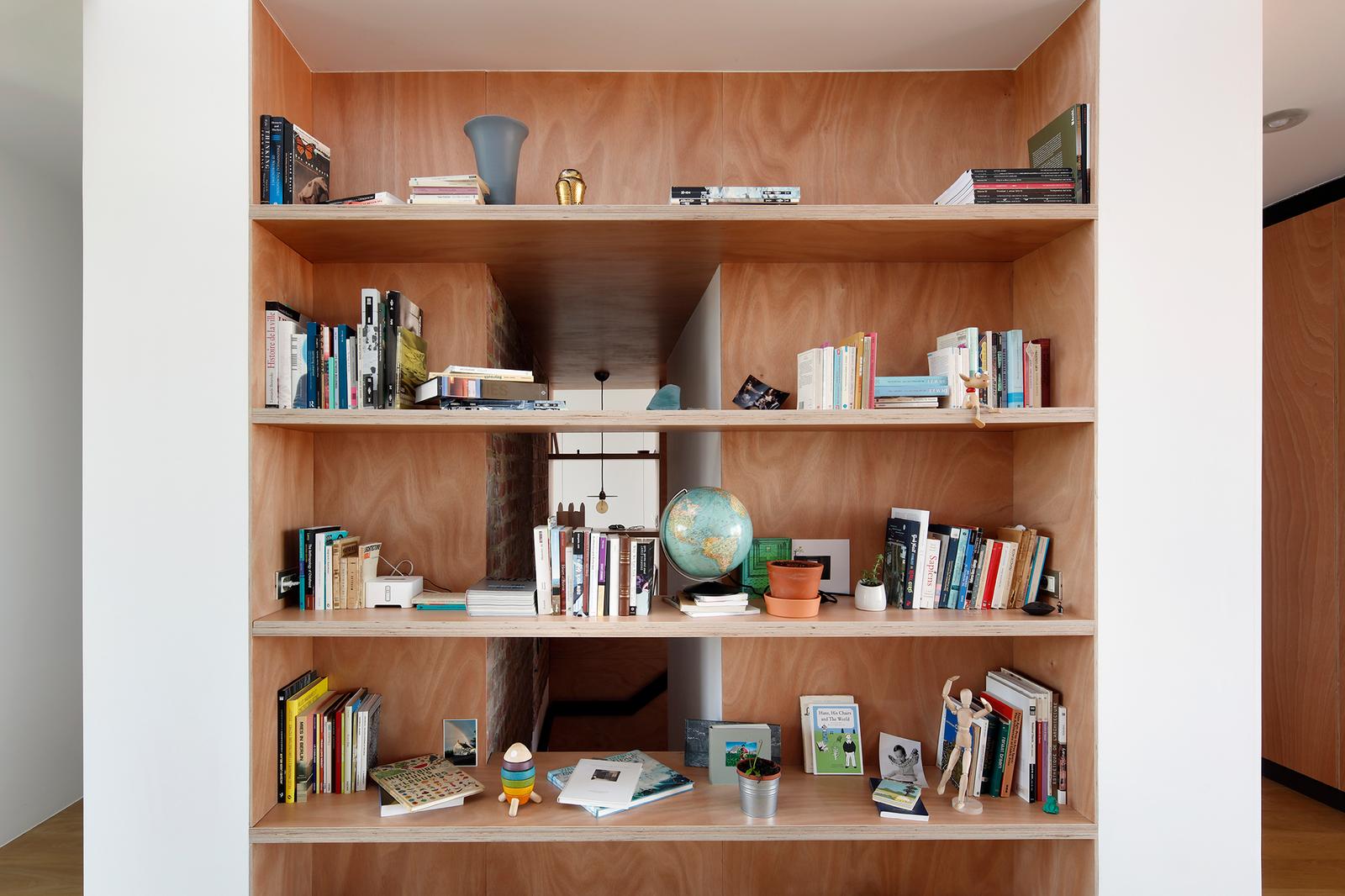 Wall-sized timber bookshelf filled with books and small objects