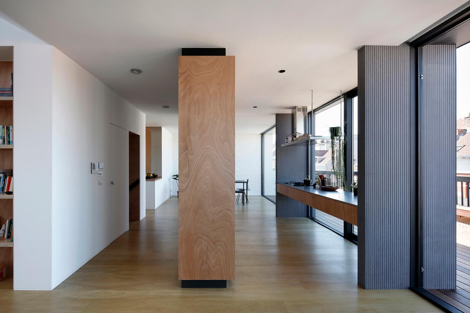 Open kitchen and living room extending along a wall of windows