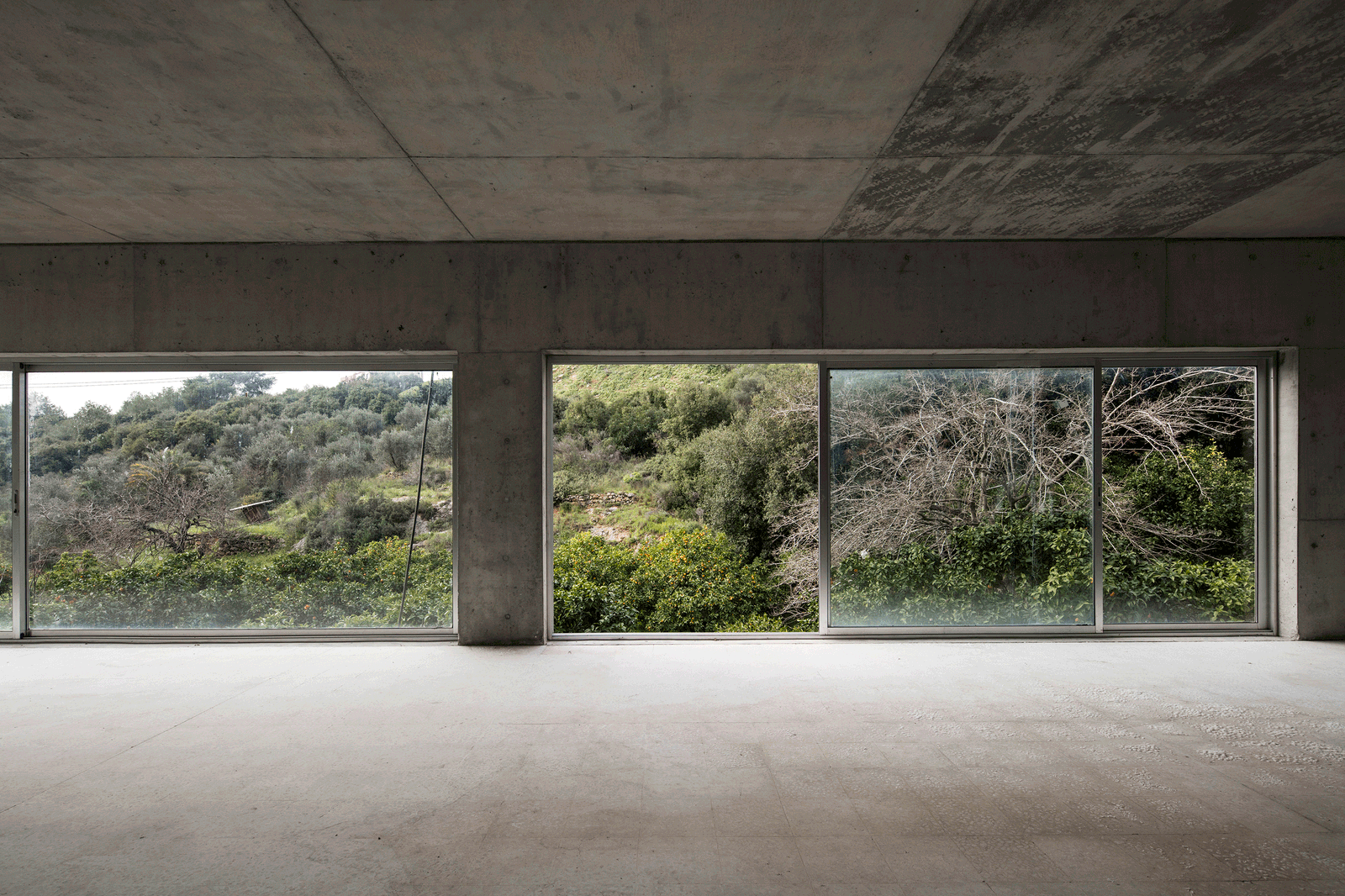 Broad concrete interior opening onto shrubs and rocky terrain