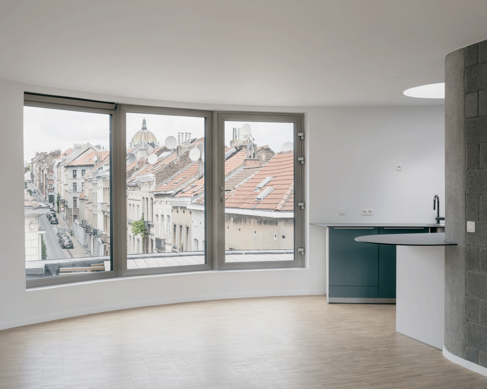 Open kitchen and living room facing a broad city window