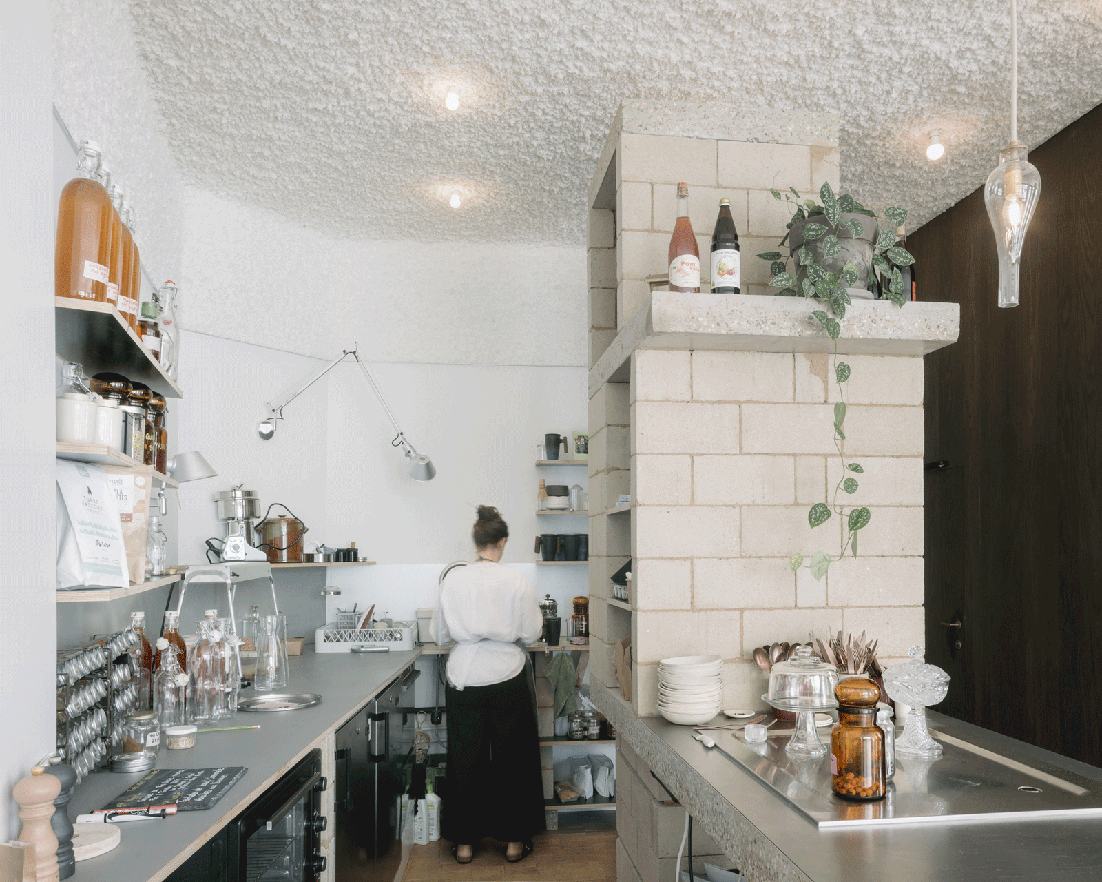 Staff member working behind a terrazzo island and product shelves