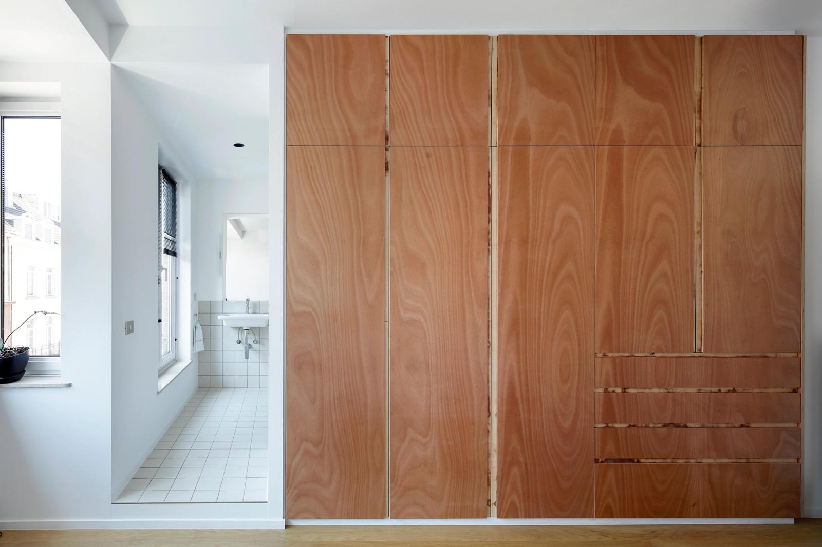 Full-height timber storage wall beside the bright kitchen