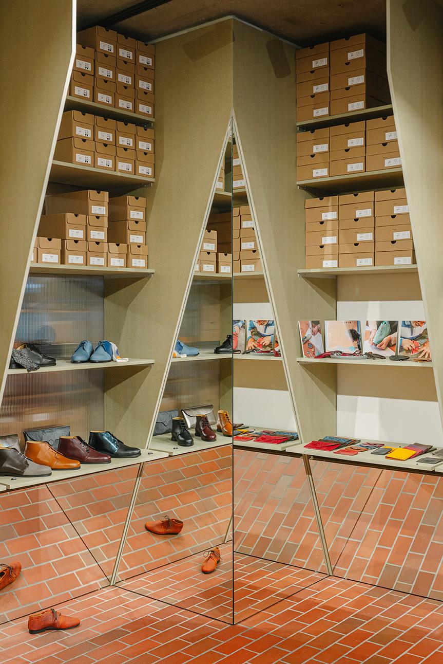 Shop corner with tall triangular shelving and repeated reflections