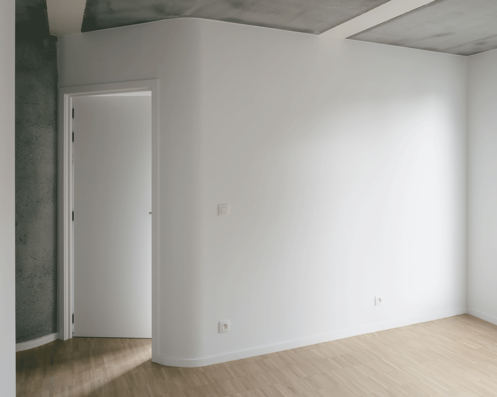 Quiet interior room combining white walls and exposed concrete