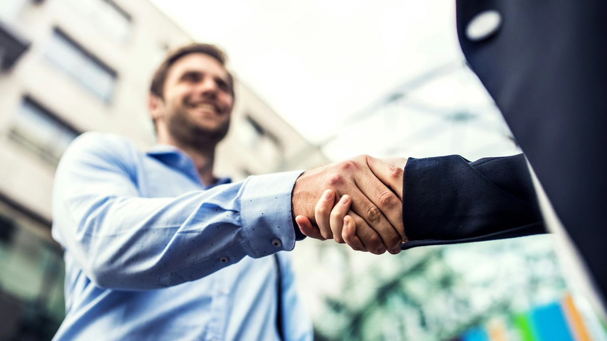 Two man in business outfit shaking hands