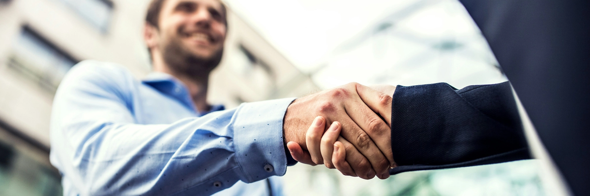 Two man in business outfit shaking hands
