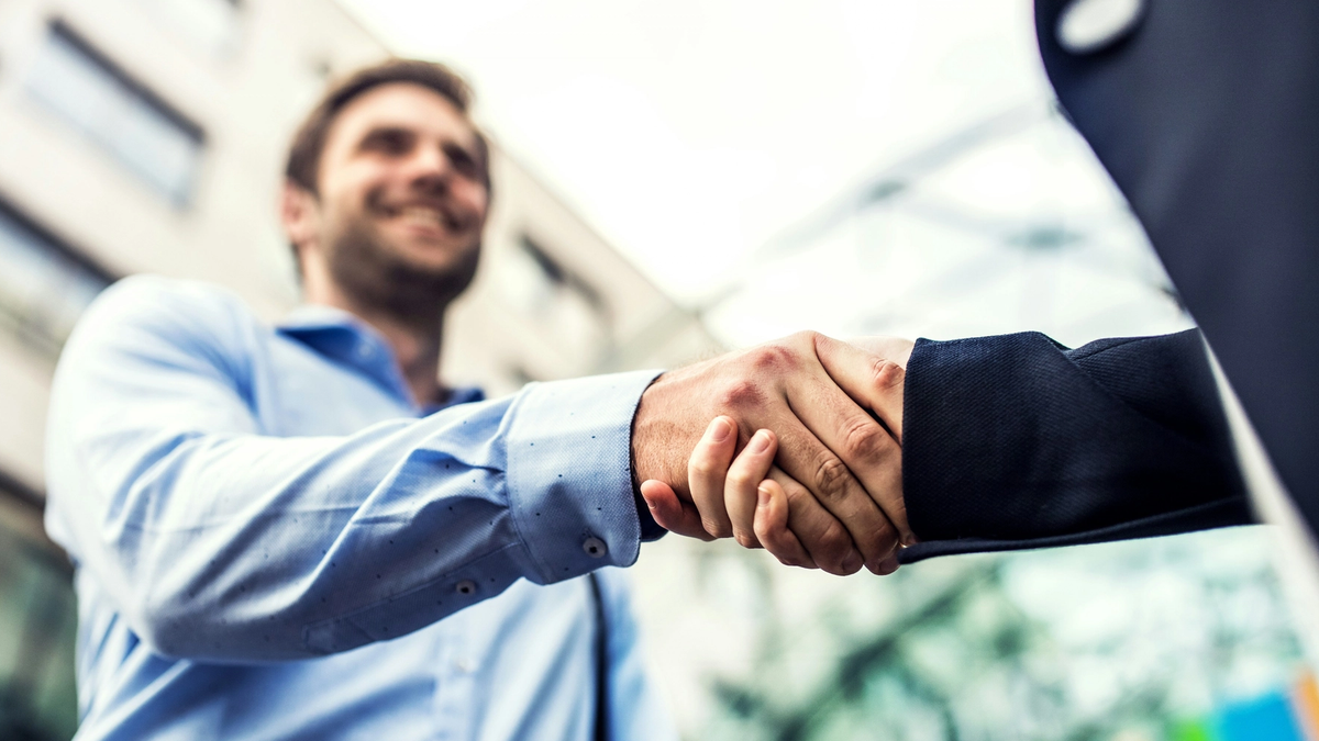 Two man in business outfit shaking hands