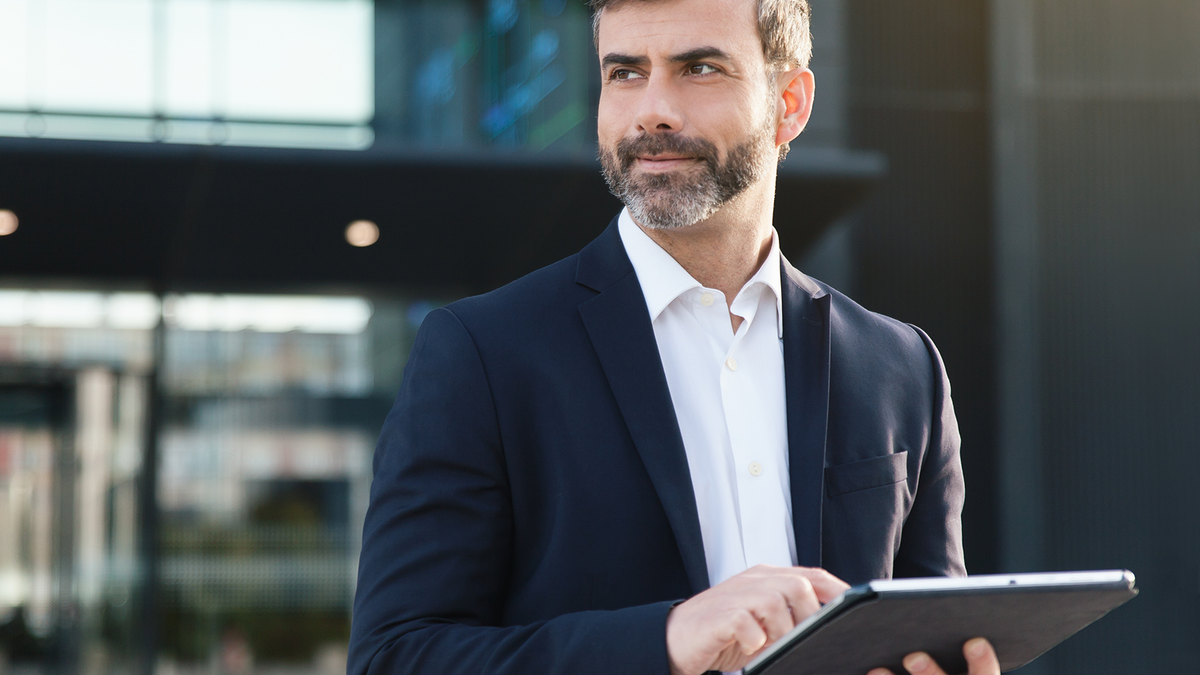 Man in suit working on an iPad
