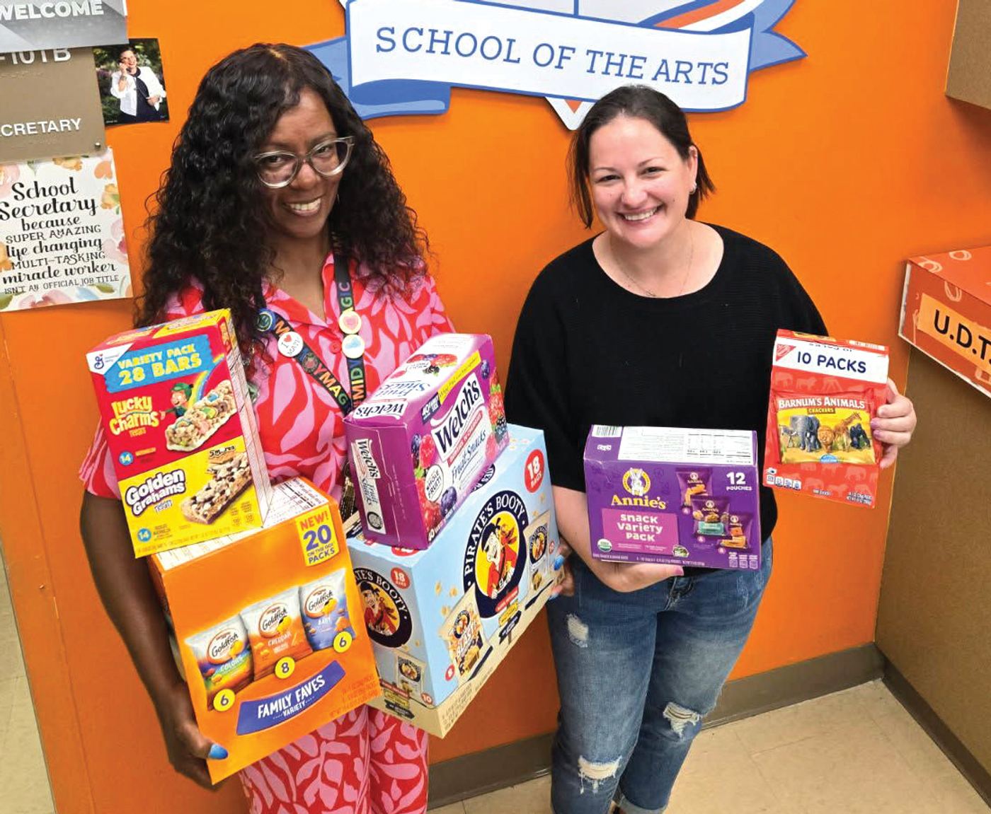 Tabasha Frederick, assistant principal at Midway Elementary School of the Arts, accepts donated snacks from Elizabeth Savettiere, a volunteer with Snacks4Students.