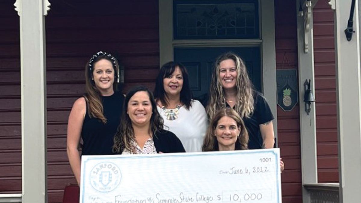 Sanford Porchfest cofounders Shelly Allen, Nancy Sepulveda, Shana Gorondy, and Kim Waters present a $10,000 check to Dr. Michele Cuomo, dean of arts and communications at Seminole State College.