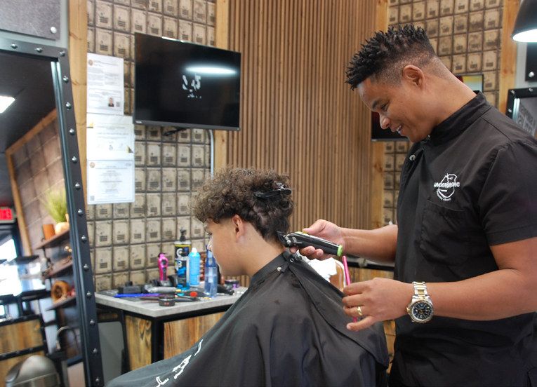 Head barber Tiano Black works his magic on a client’s hair at Underground One in Oviedo.