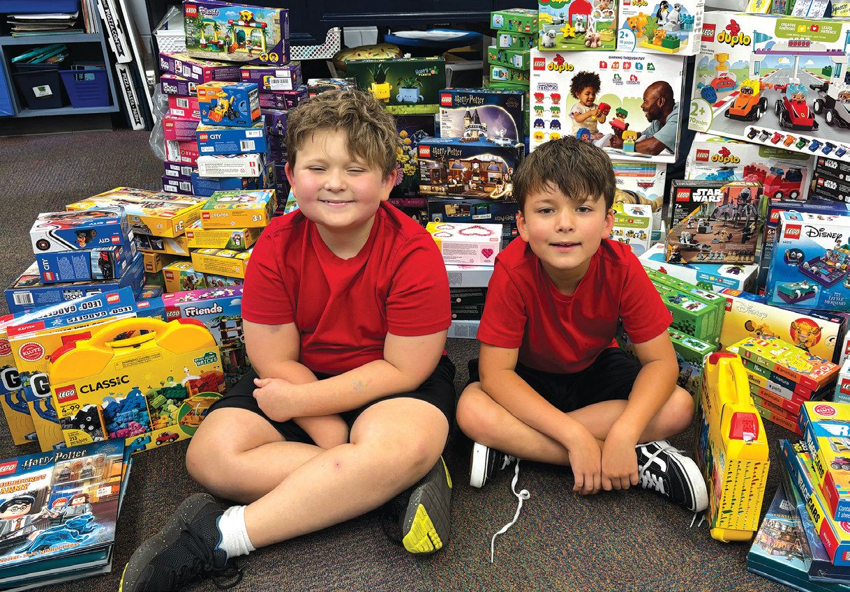 Elliott with his younger brother Oliver, surrounded by donated Lego sets