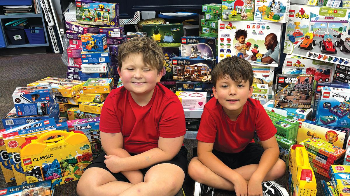 Elliott with his younger brother Oliver, surrounded by donated Lego sets