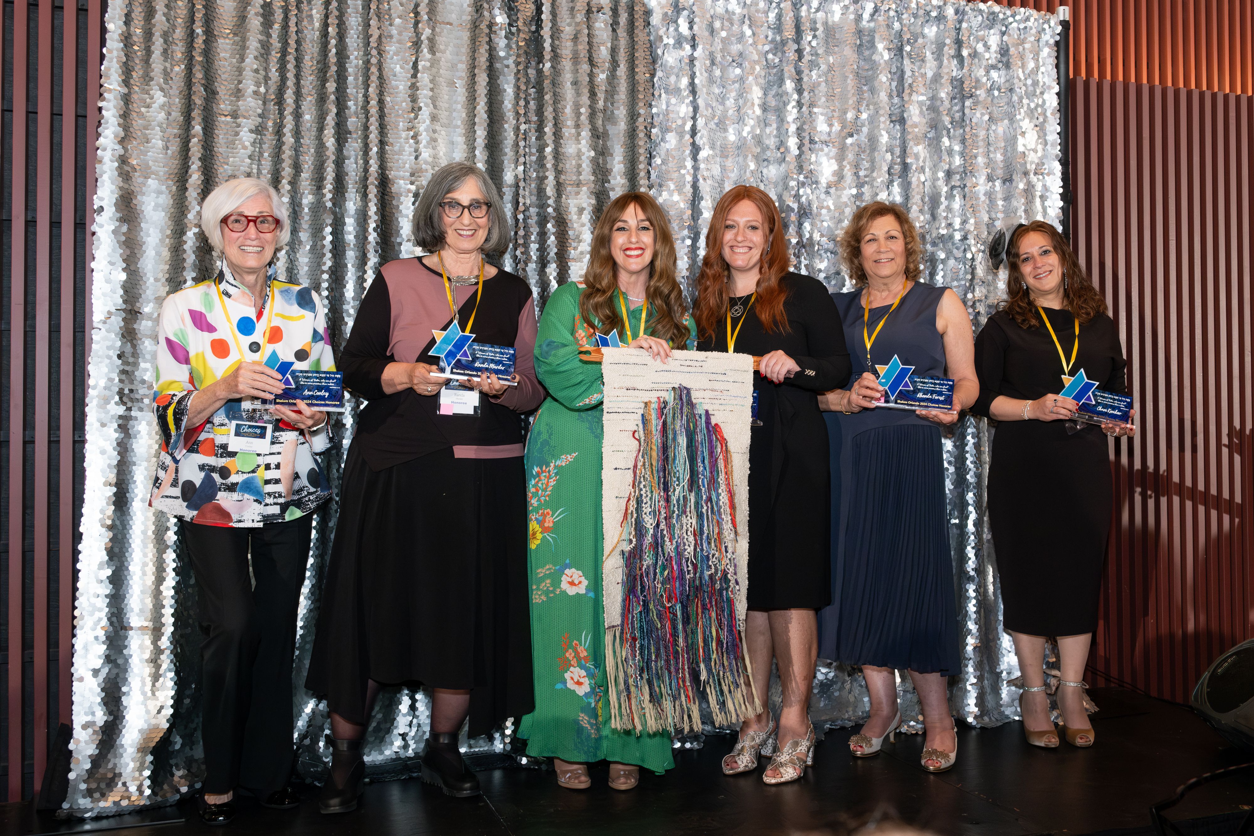 The six Choices 2024 honorees on stage holding a woven tapestry