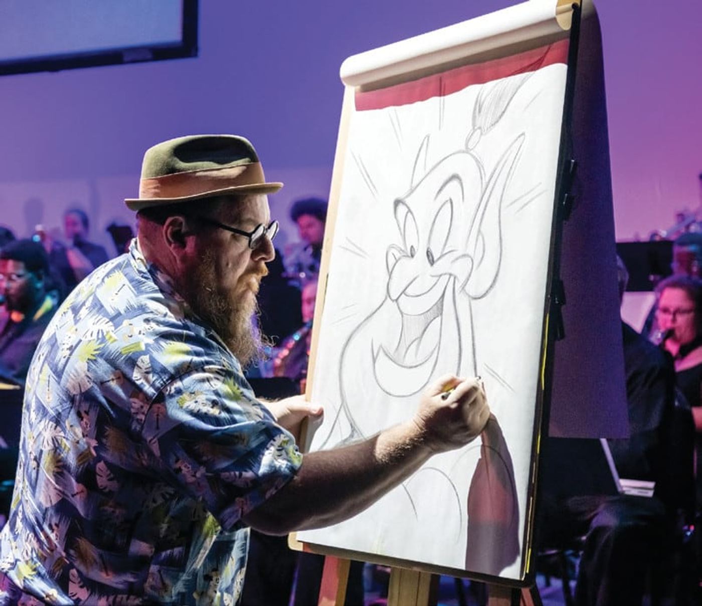 Jason Zucker drawing the Genie on stage at a CFCArts concert