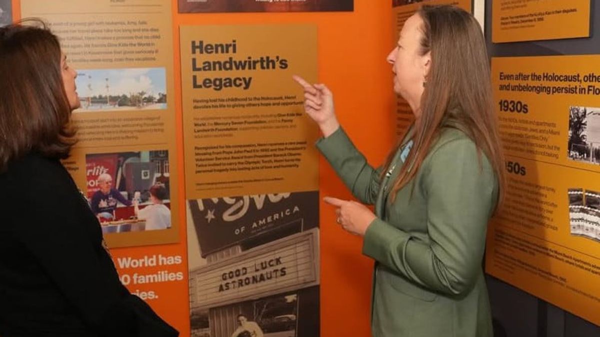 Visitors viewing the Henri Landwirth exhibit panels