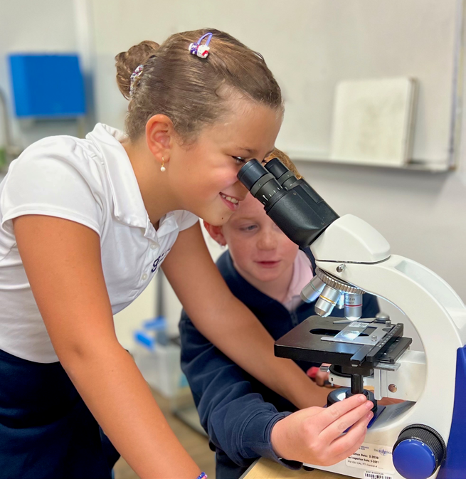 A Gotlib Jewish Academy student looks through a microscope