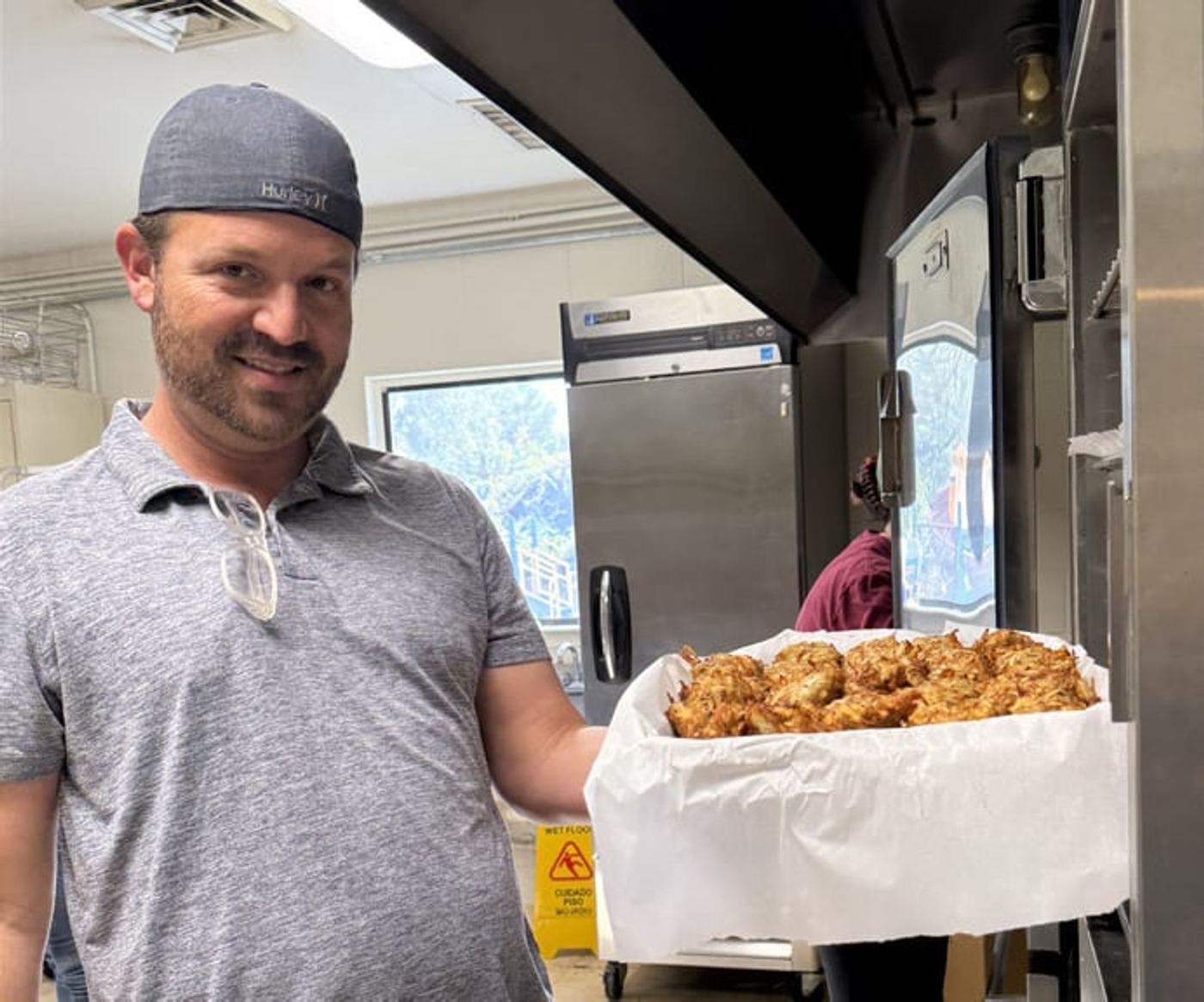 Danny Sabag holding a tray of latkes