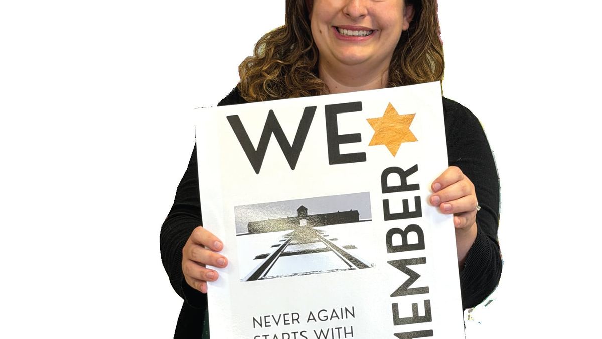 Megan Thompson holding a We Remember sign