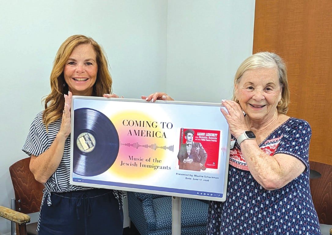 Maxine Schackman and her daughter Laura Cohn holding a framed display