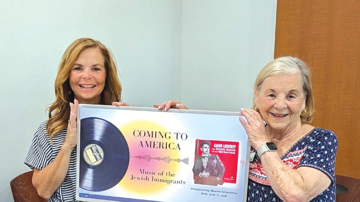 Maxine Schackman and her daughter Laura Cohn holding a framed display