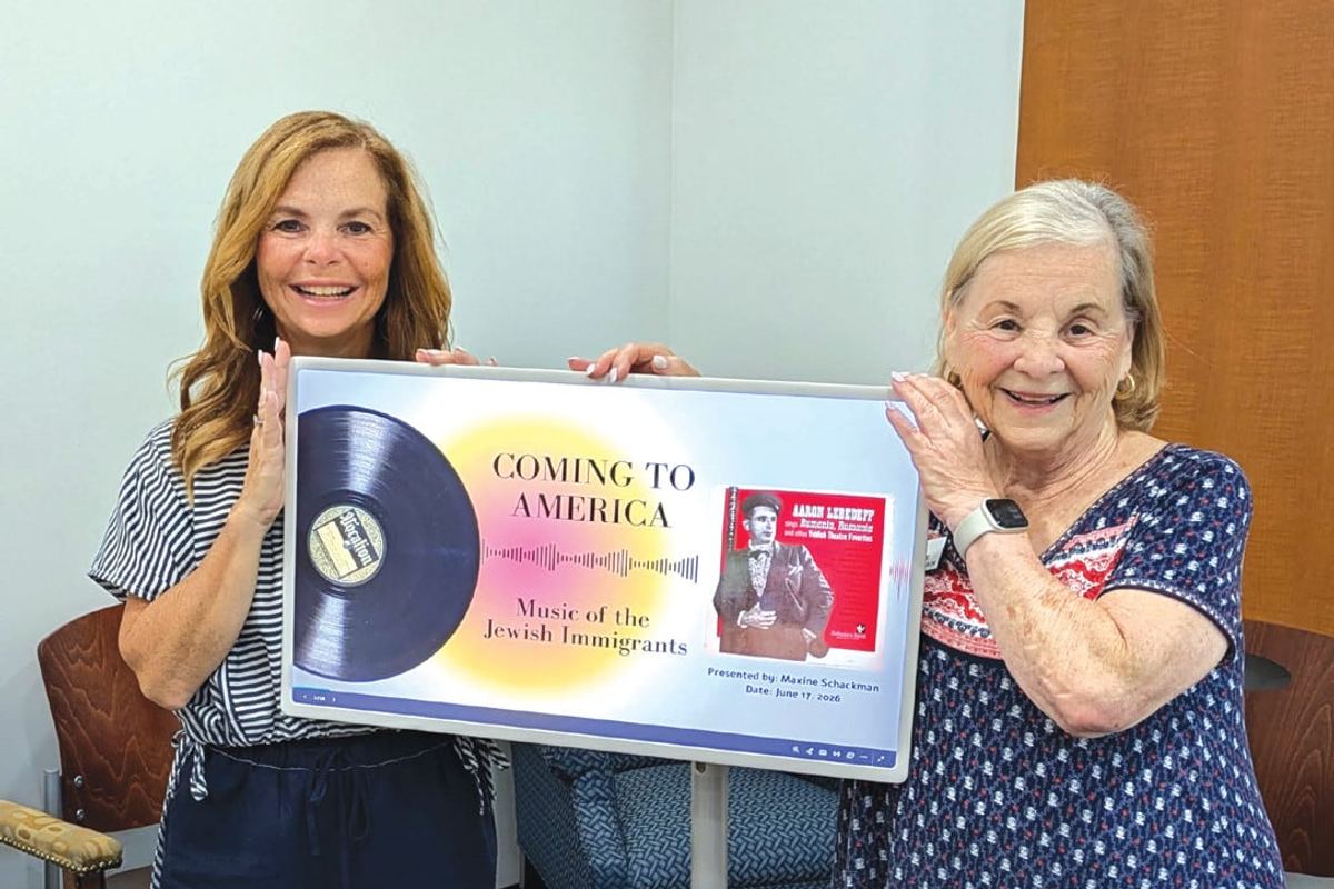 Maxine Schackman and her daughter Laura Cohn holding a framed display