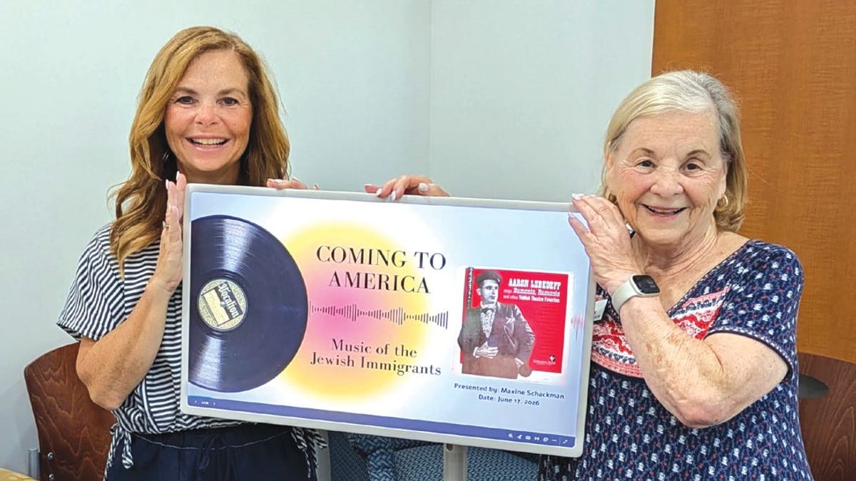Maxine Schackman and her daughter Laura Cohn holding a framed display