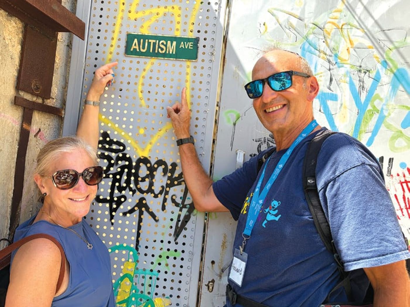 Rachel and Howard Blas beside an Autism Avenue street sign