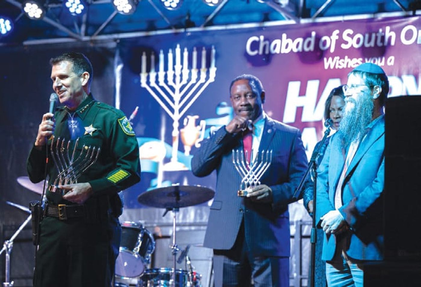 Sheriff John Mina, Jerry and Val Demings, and Rabbi Yosef Konikov on stage