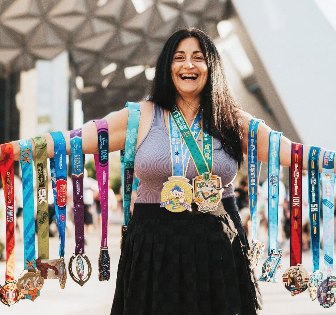 Ilana Robinson showing her Disney race medals