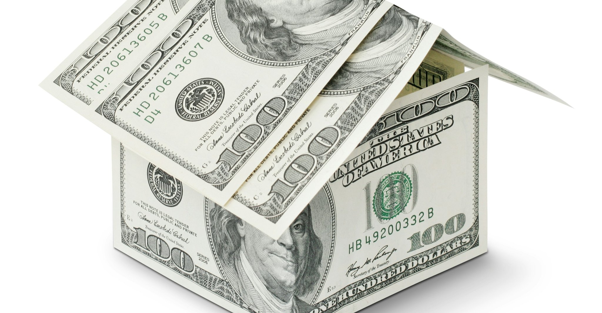 US $100 dollar bills stacked into a house