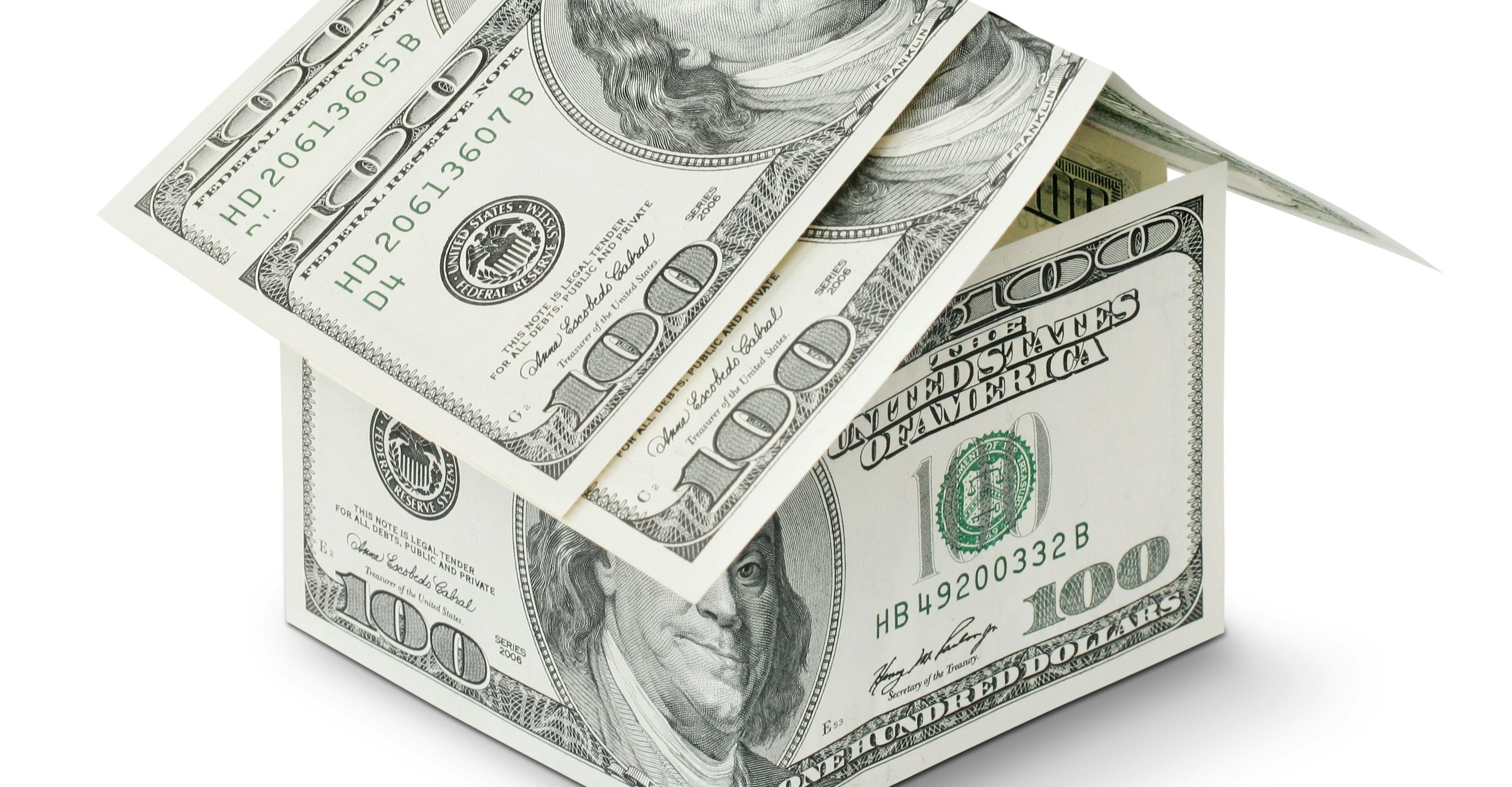 US $100 dollar bills stacked into a house