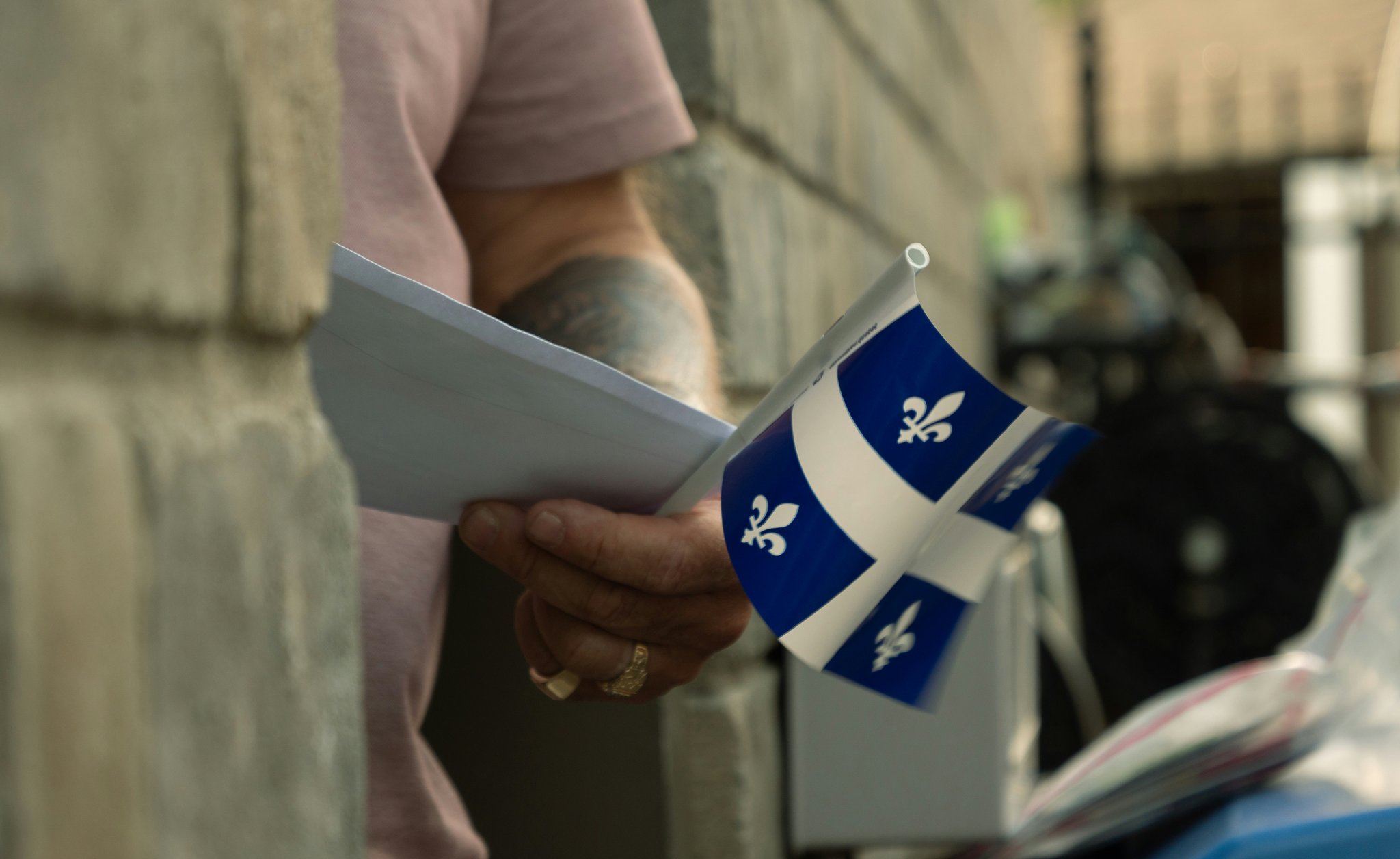 Man holding papers and a flag of Quebec