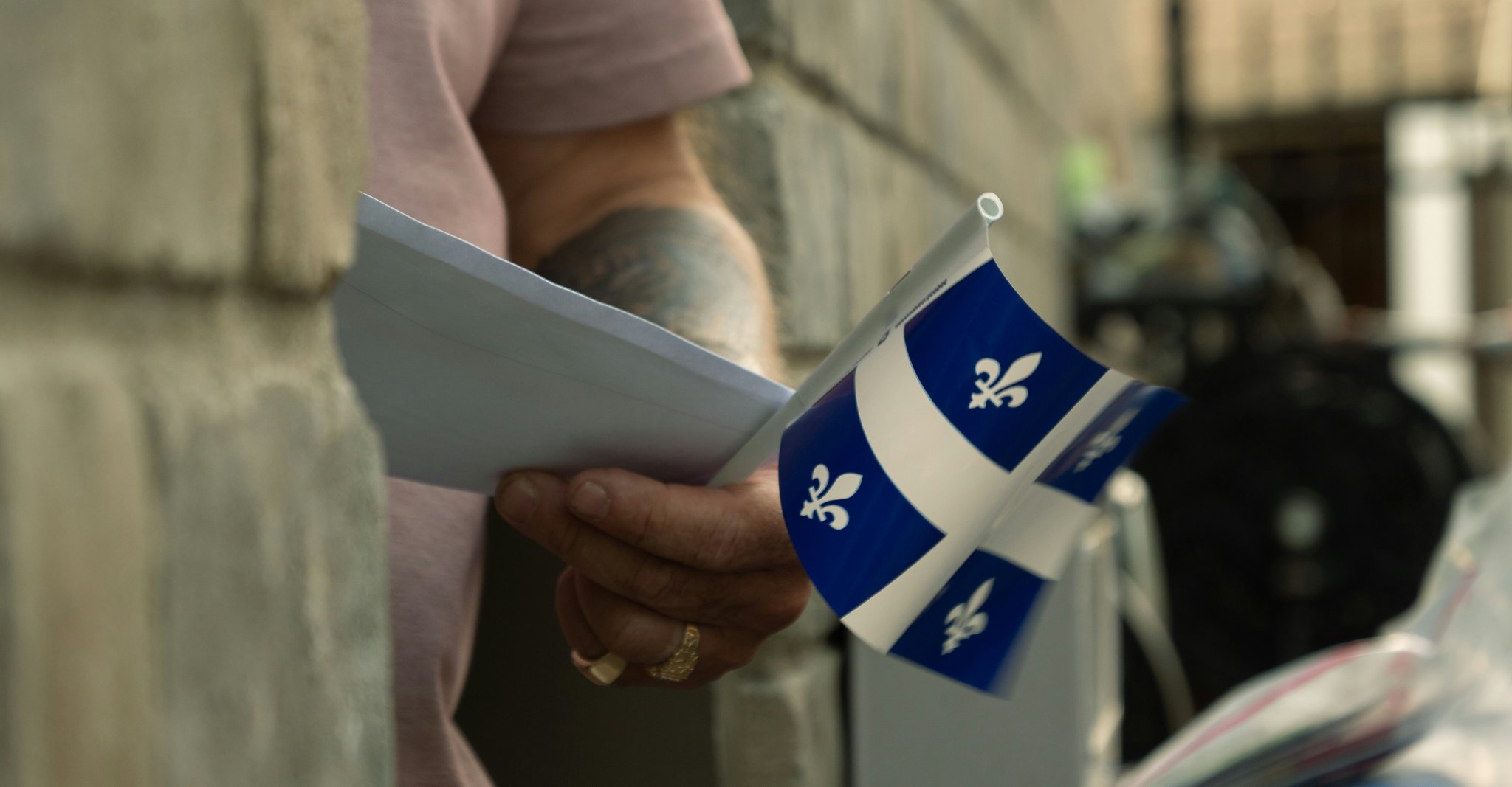 Man holding papers and a flag of Quebec