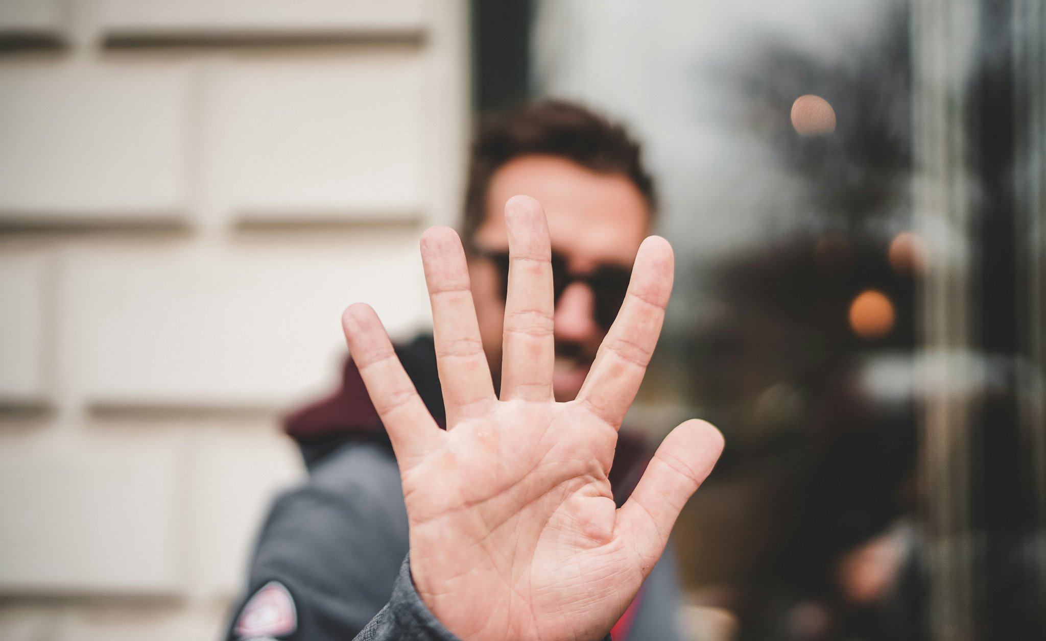 Person holding up 5 fingers