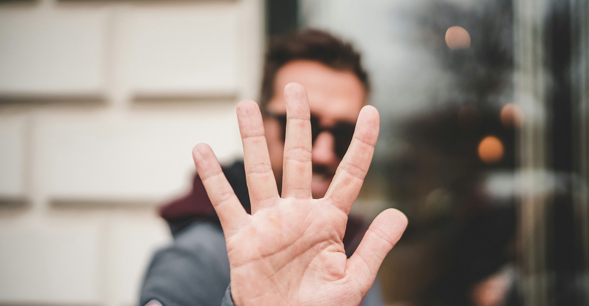 Person holding up 5 fingers