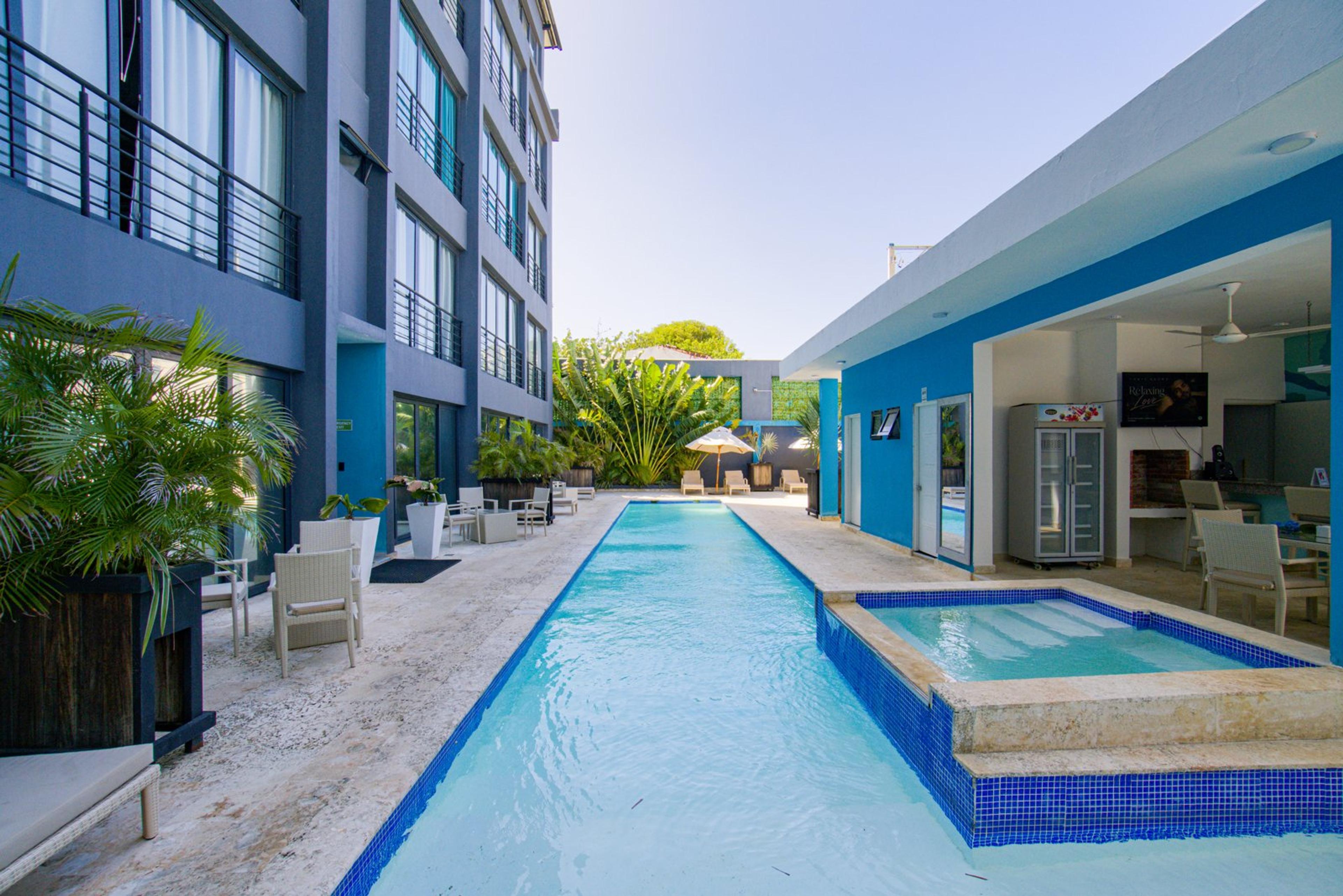 The long outdoor pool beside the apartments and shaded lounge